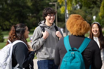 Four students talking with one another outside