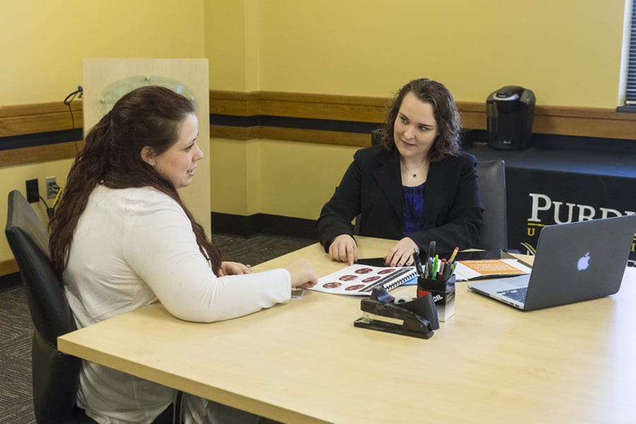 2 Students sitting on desk going over presentation