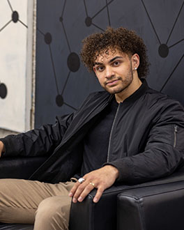 Student sits in a black arm chair