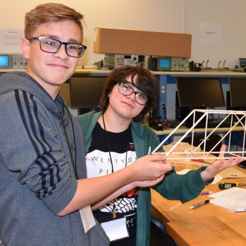 Ayden Wollweber, Vivianna Ruiz and Timothy Pierce display their wooden bridge project created at the high school camp in 2019.