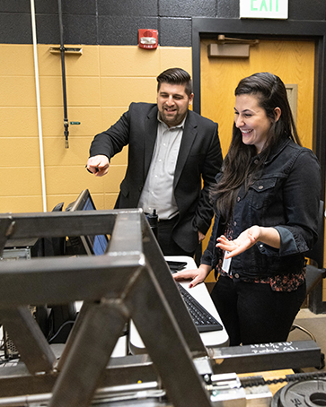 A student and professor work on a computer in the Steel Bridge Room