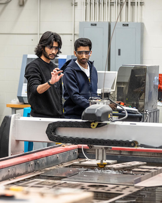 PNW students use a water jet to cut material in the Design Studio