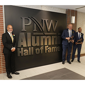 PNW 2023 Alumni Hall of Inductees Alfredo “Al” Sori, Stewart “Stu” McMillan and Robert Johnson III in front of the Alumni Hall of Fame Display in the Student Union and Library Building