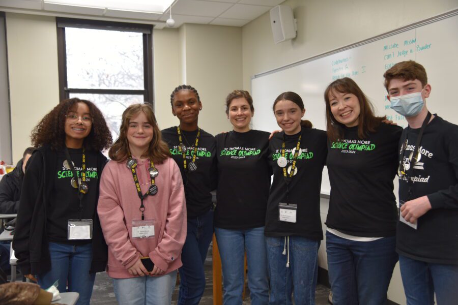 Students from the St. Thomas More Science Olympiad gather with their teachers for a group photo.