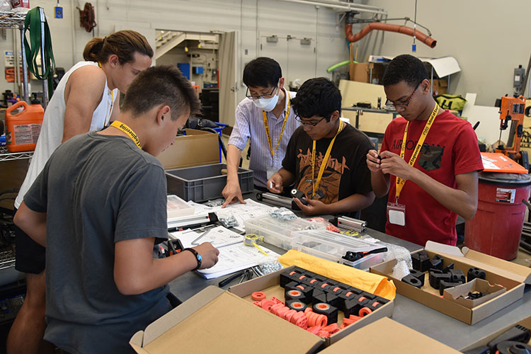 High school engineering camp participants work at a lab bench.