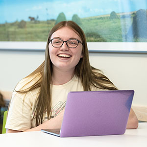 A student works on a purple laptop.