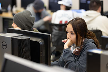 A student sits in front of a computer.