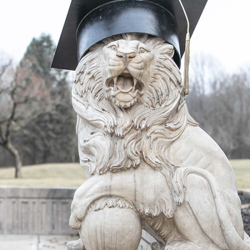 A PNW Lion Sculpture wearing a commencement cap