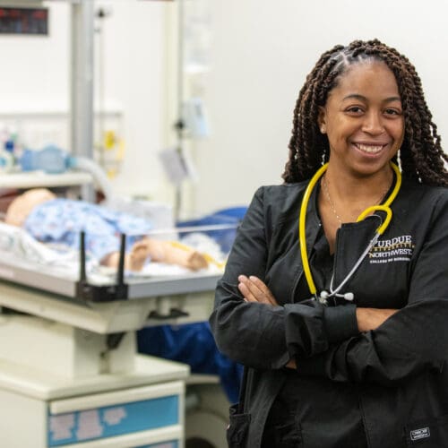 PNW student stands within the Robert J. Milos, M.D. & Margaret J. Milos, R.N. Nursing Assessment Center.