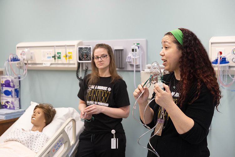 Two nursing teachers explaining how to put a breathing mask on