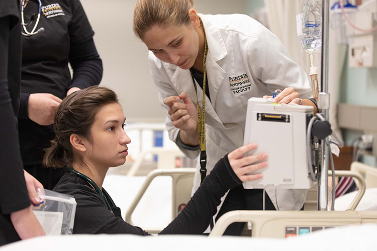 A student and instructor work in a nursing lab.