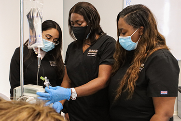 Nursing students looking at a device
