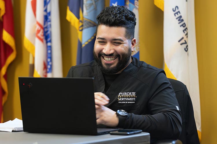 A student works on a laptop in the veteran services office.