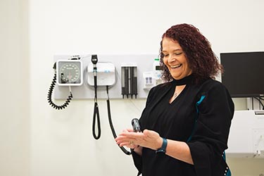 A nursing professor works with diagnostic equipment