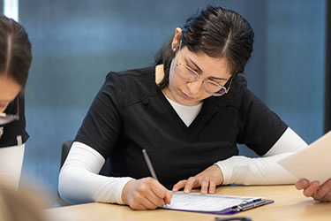 A nursing student writes in a notebook