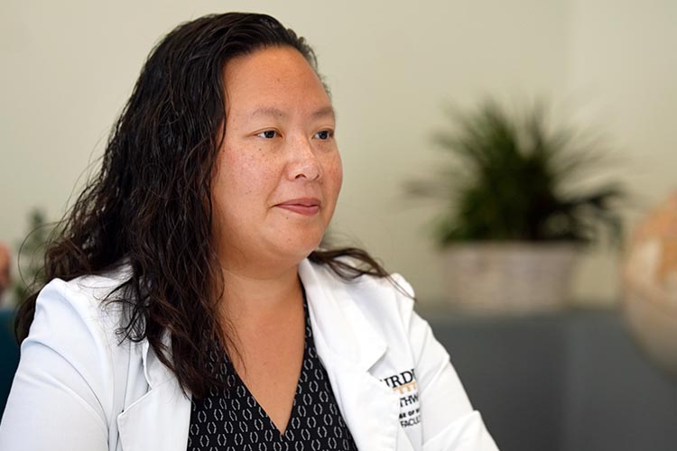 A nursing faculty member in a lab coat.