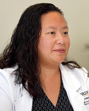 A nursing faculty member in a lab coat.