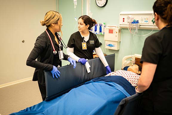 PNW Students working with the mannequin in the Nursing Lab.