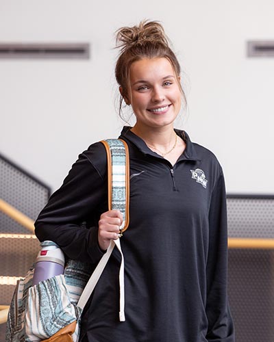 A PNW student poses with a backpack on campus.