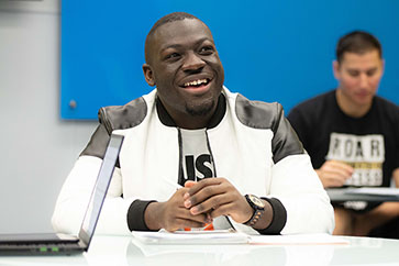 A PNW student in a white jacket in the classroom.