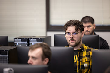 Students sit in a computer lab classroom.