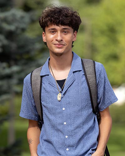 A PNW student stands outdoors on campus