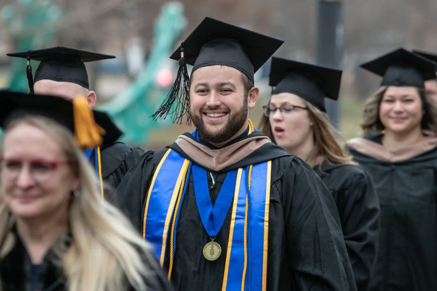 Students march toward commencement.