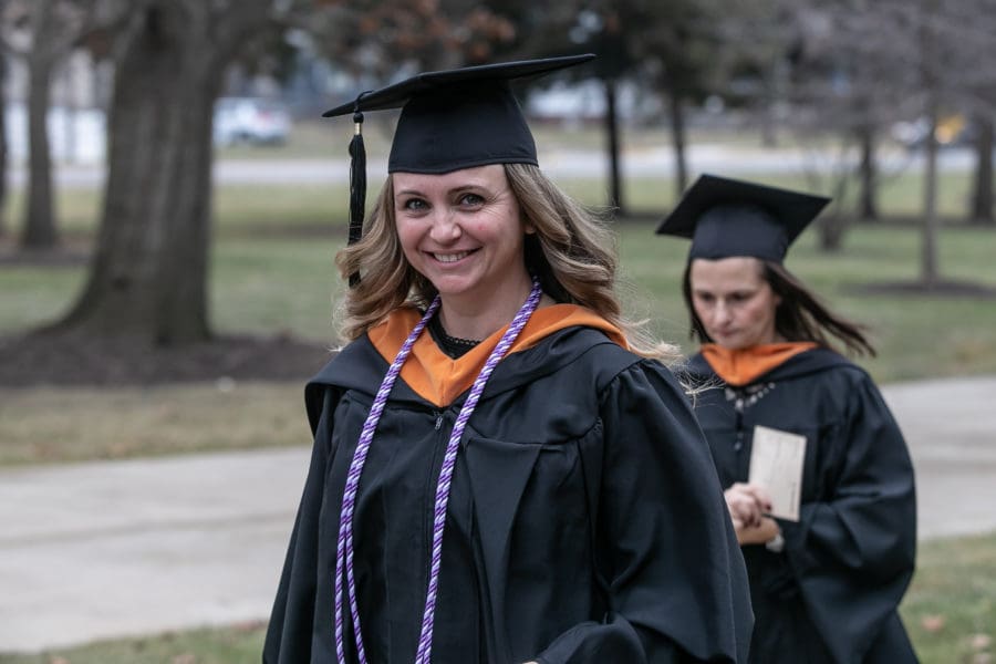 A student smiles in her cap and gown.