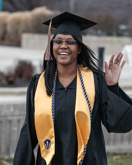 A student waves at commencement.