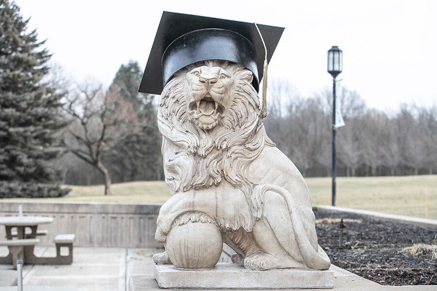 A PNW Lion Sculpture wearing a commencement cap