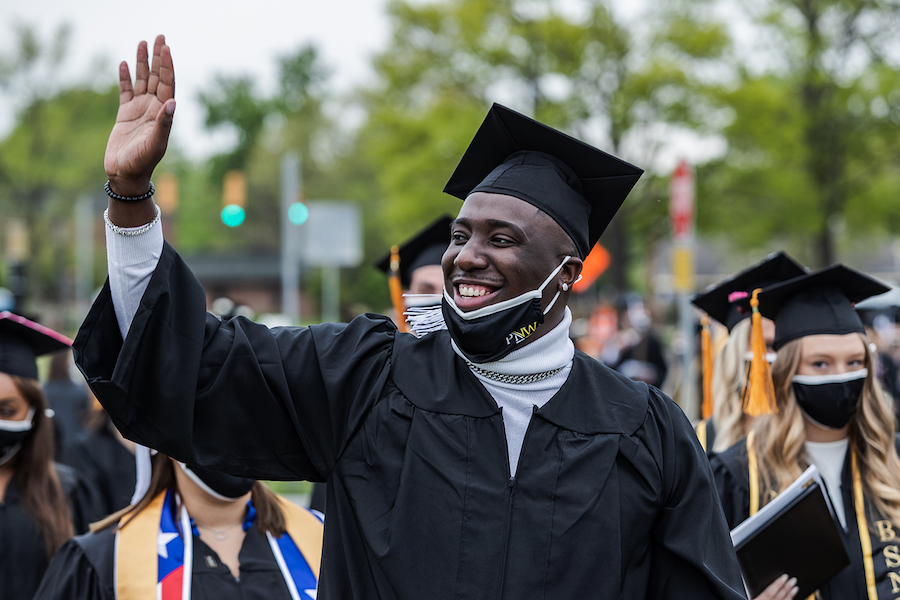 Student waving at commencement.