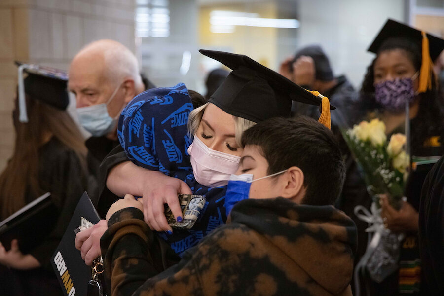 A grad hugs her family.
