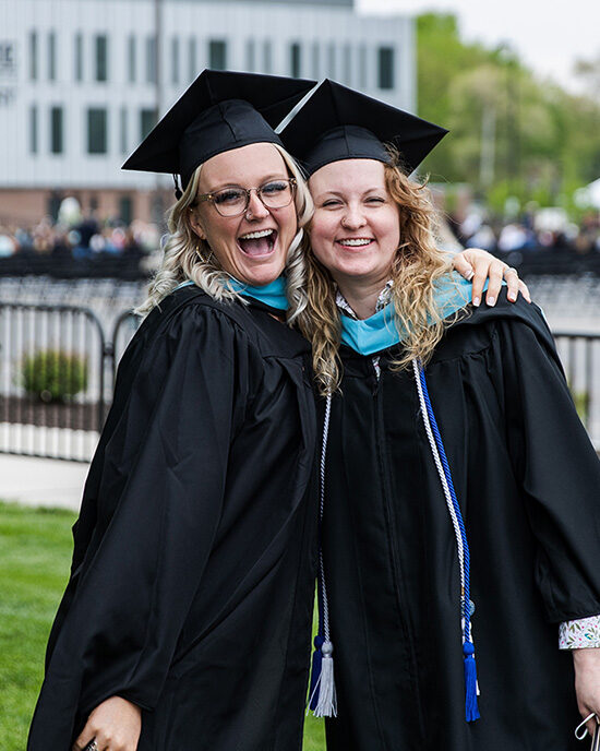 Two PNW graduates smile together at Spring 2021 commencement
