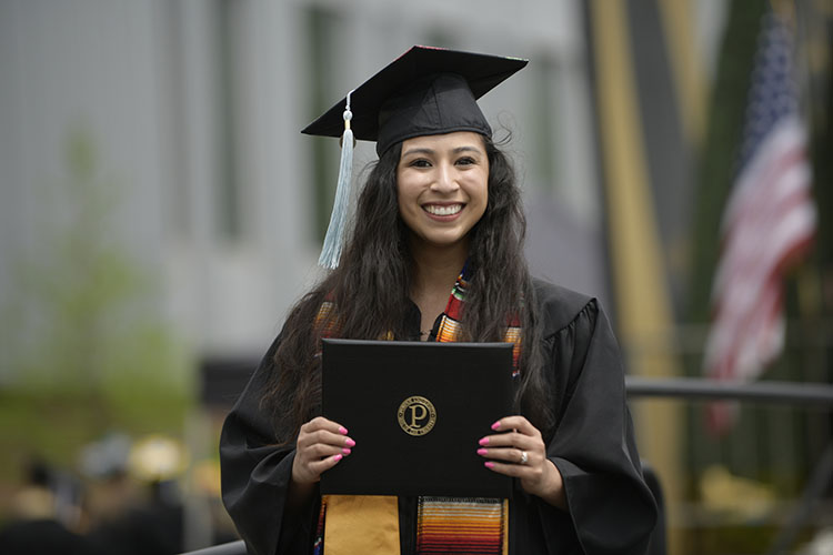A PNW graduate poses with her diploma.