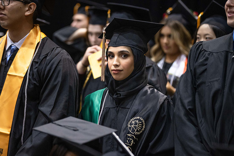 Student in a head covering and cap and gown