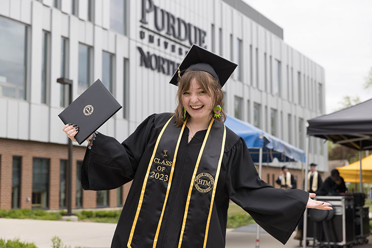A PNW HTM graduate poses with her diploma