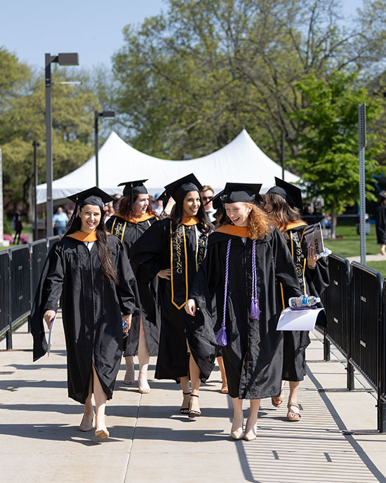 A group of graduates walk into a commencement ceremony