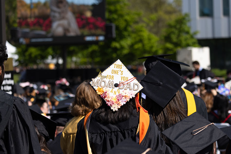 A student's graduation cap that reads "This ones for you Mom and Dad"