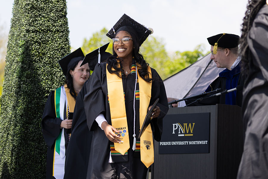 A student walks across the stage during commecement