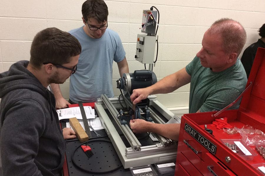 CMEC students working on a piece of machinery