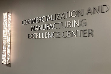 A wall sign that reads "Commercialization and Manufacturing Excellence Center"
