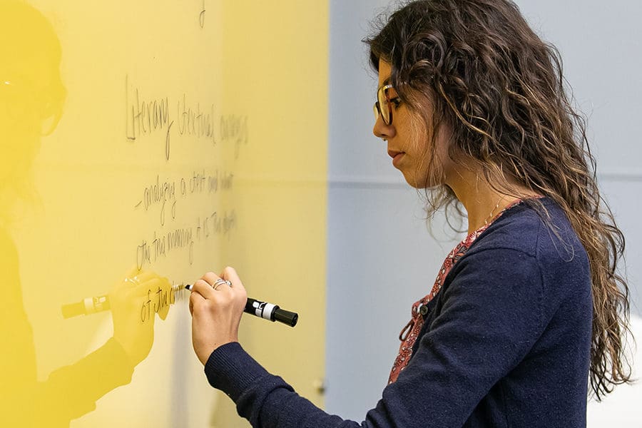 Female writing on a smart board