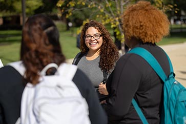 Three students talking outside on the PNW campus 363x242
