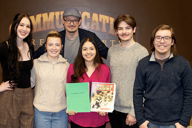 Five PNW communication students stand with studio technician Jake Giles and pose with their original script.