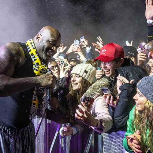 Students cheering and reaching over barricade taking photos with DJ Diesel (AKA Shaquille O'Neal)