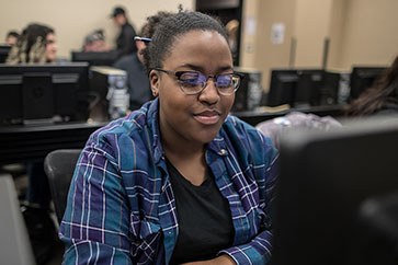 A PNW students works in a computer classroom