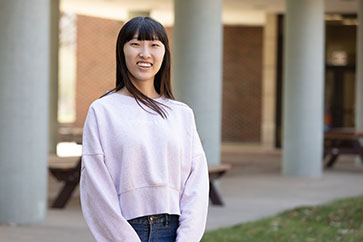 A PNW student stands outdoors