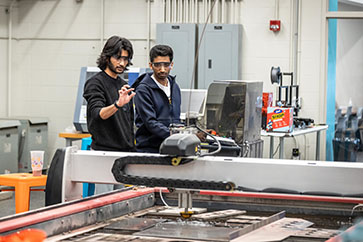 Students work with a water jet cutter