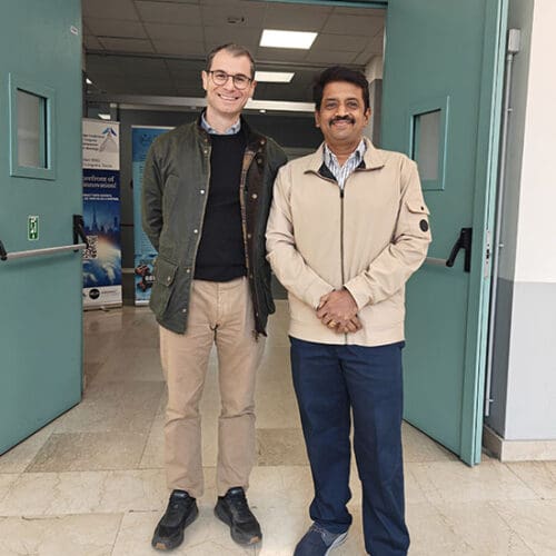 Alfonso Pagani and Magesh Chandramouli stand together in a doorway