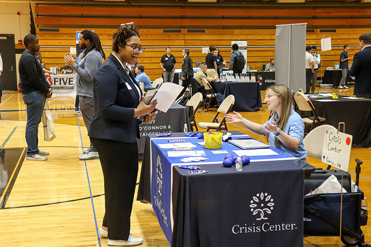 The PNW 2025 Fall Career Expo is a career fair for students and alumni of Purdue University Northwest that are seeking full time employment and internships across all industries and academic majors. A student talks to an employer during a career fair.